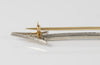 Broche flecha en oro blanco 18k con brillantes y esmeraldas