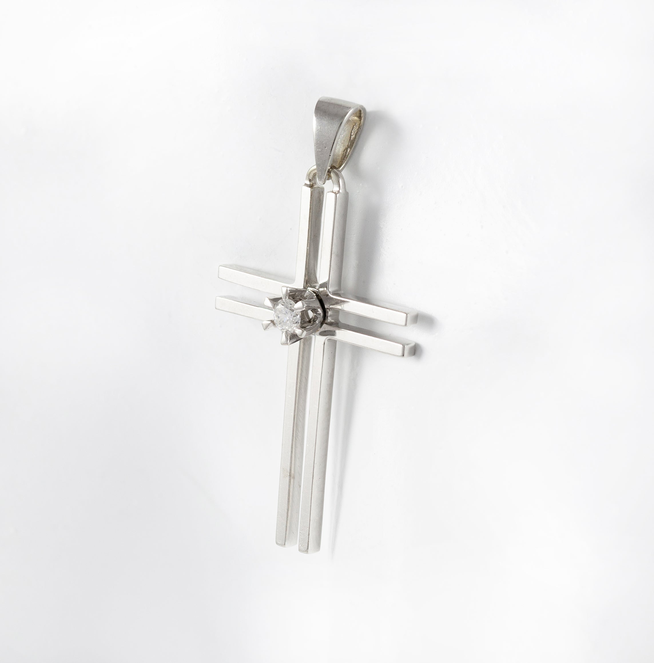 Colgante cruz en oro blanco 18k con brillante