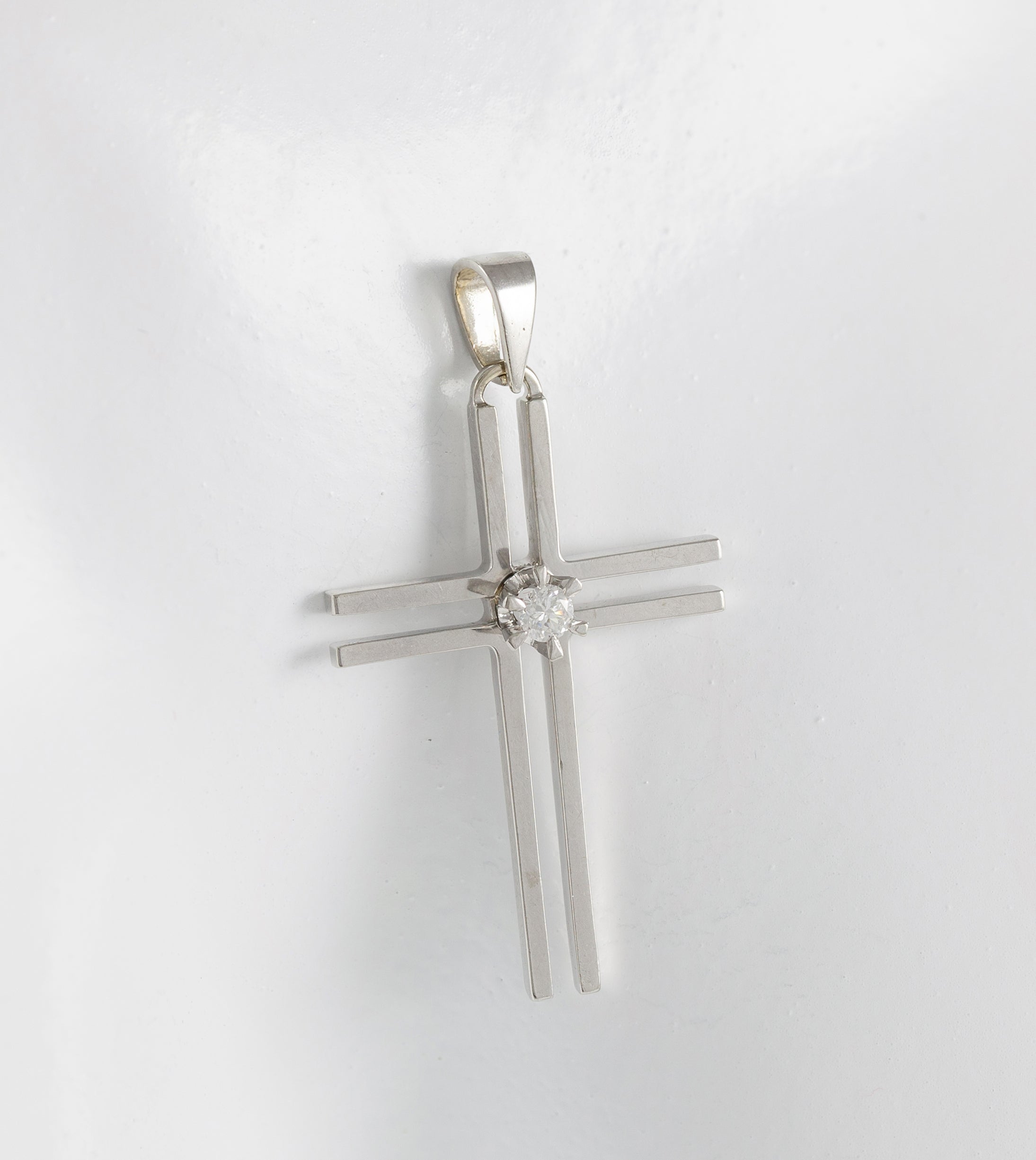 Colgante cruz en oro blanco 18k con brillante