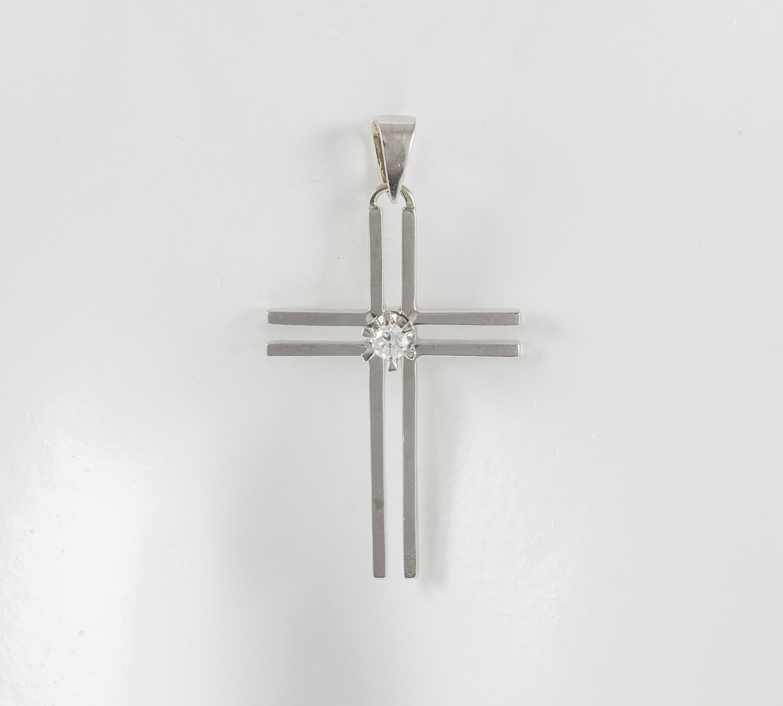 Colgante cruz en oro blanco 18k con brillante