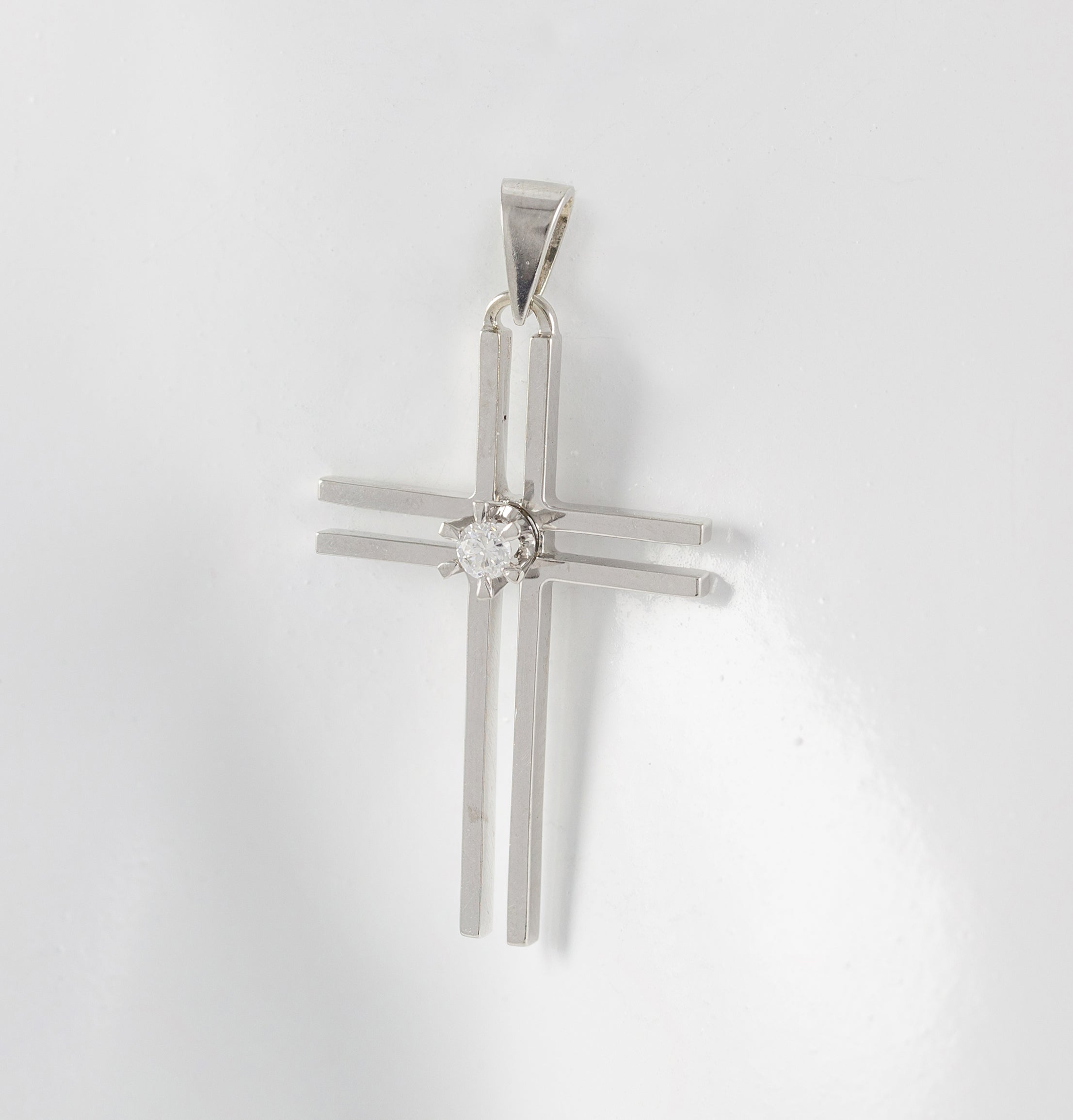 Colgante cruz en oro blanco 18k con brillante